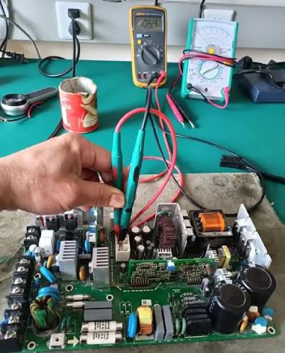 Technician testing a circuit board during repair